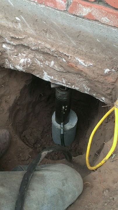 This image shows a hydraulic jack installed beneath the slab of a home. We utilize these hydraulic jacks to life your home and bring it back to level. 