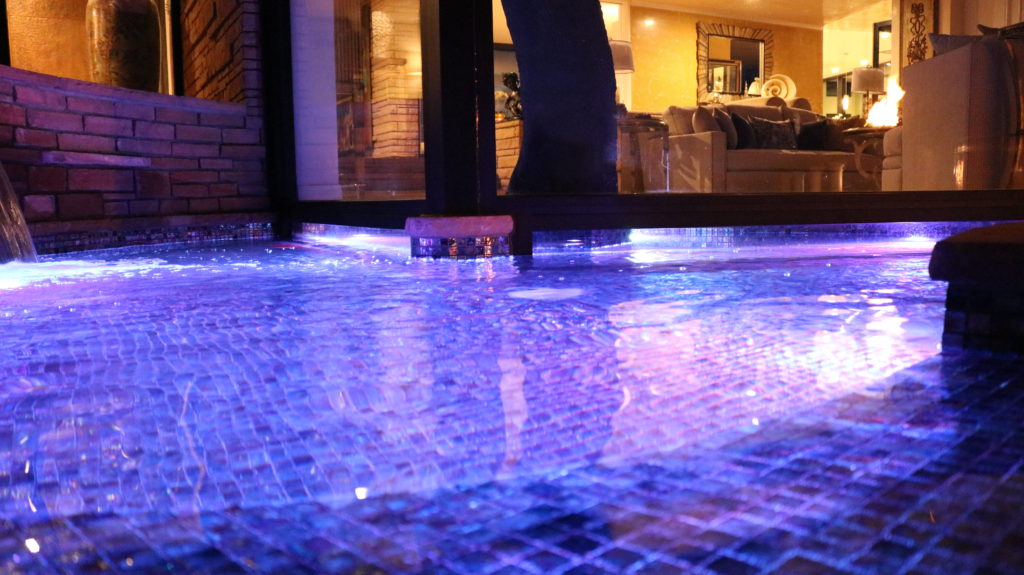 Our House on a Hill project includes a gorgeous display of LED lit water features paired elegantly with fire pit lighting. This is the completion of a backyard renovation project that lasted 6 months from start to finish. This image shows our LED lit water fountain on our raised deck. 