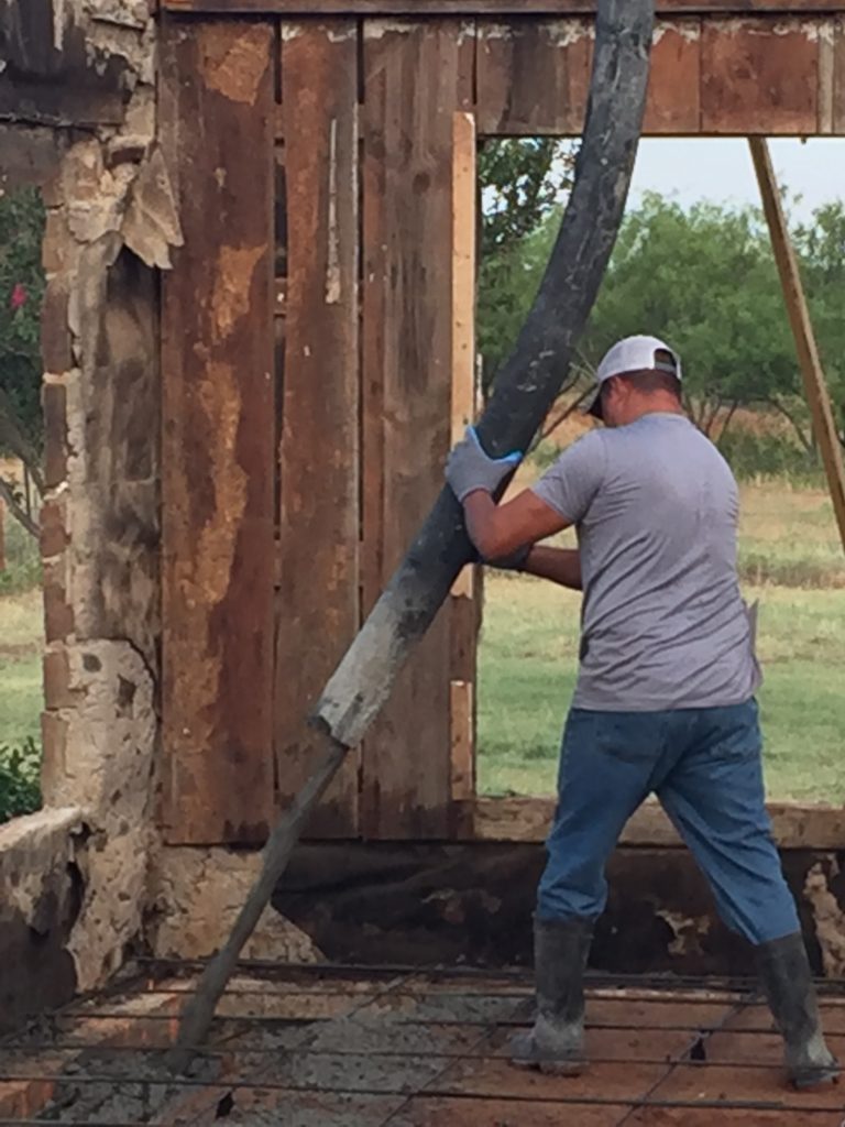 Here you can see our crew pouring our concrete slab inside of this home. Wet cement is extremely heavy. Therefore, we station a crane to hold our applicator so we can carefully apply the wet cement to the interior of the home - creating a firm foundation for our client.